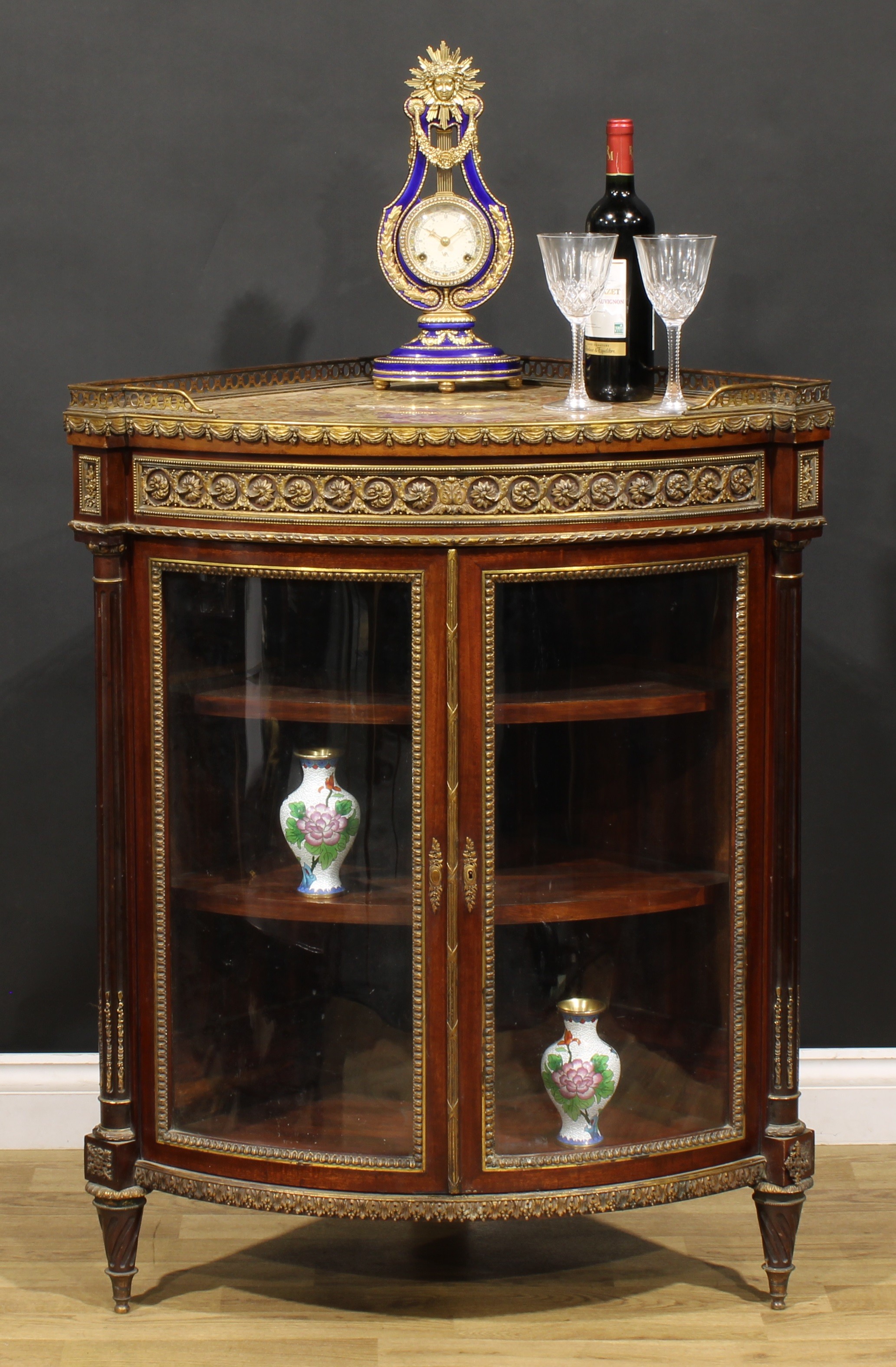 A Louis XV Revival gilt metal mounted mahogany floor standing corner vitrine, marble top with