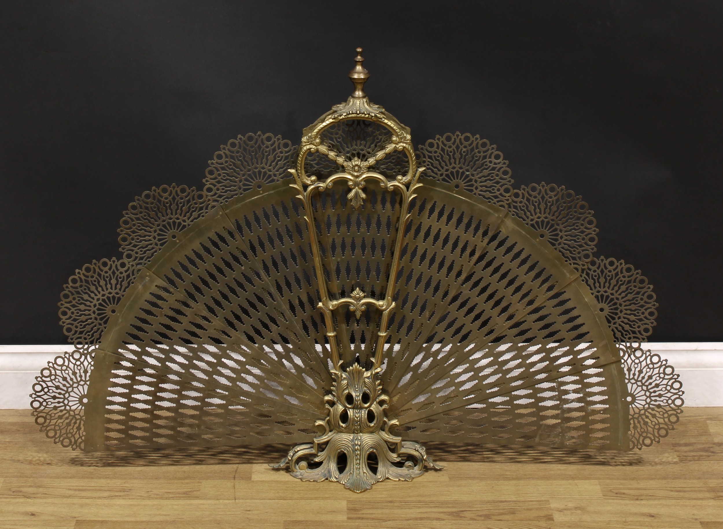 A Louis XV style gilt metal fan fire guard, pierced and cast with leafy scrolls, 75cm high, 109cm