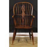 A 19th century elm and ash Windsor elbow chair, shaped and pierced wheelback splat, saddle seat, H-