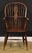 A 19th century elm and ash Windsor elbow chair, shaped and pierced wheelback splat, saddle seat, H-