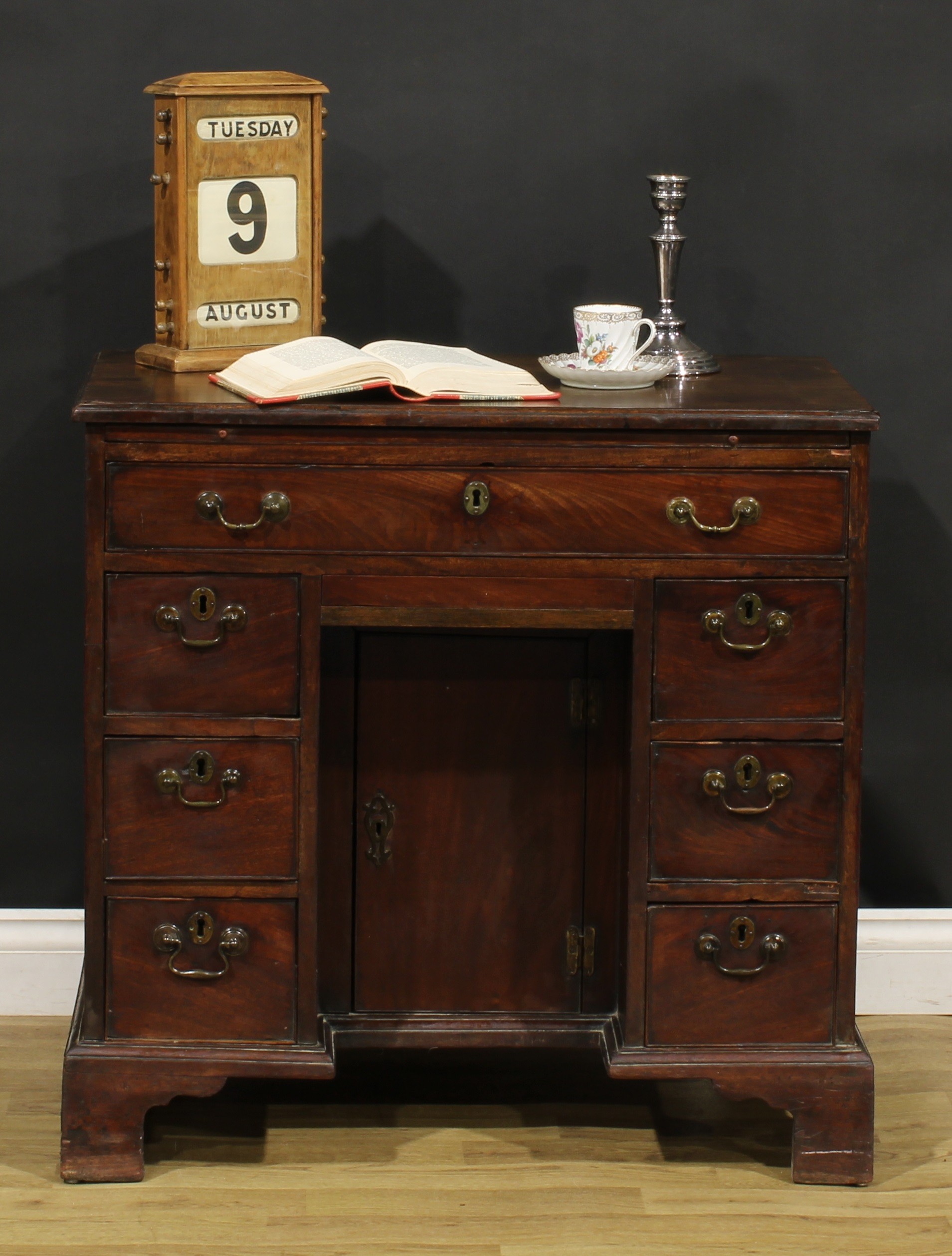 A George III mahogany kneehole desk, slightly oversailing top with moulded edge above a slide and