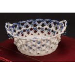 An Lowestoft Pine Cone pattern two-handled oval basket, central oval reserve painted in underglaze