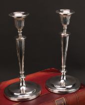 A pair of George III silver table candlesticks, detachable nozzles, fluted bell shaped sconces and