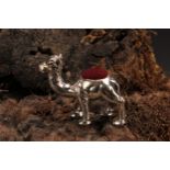 A sterling silver novelty pin cushion, as a camel, 3.5cm long