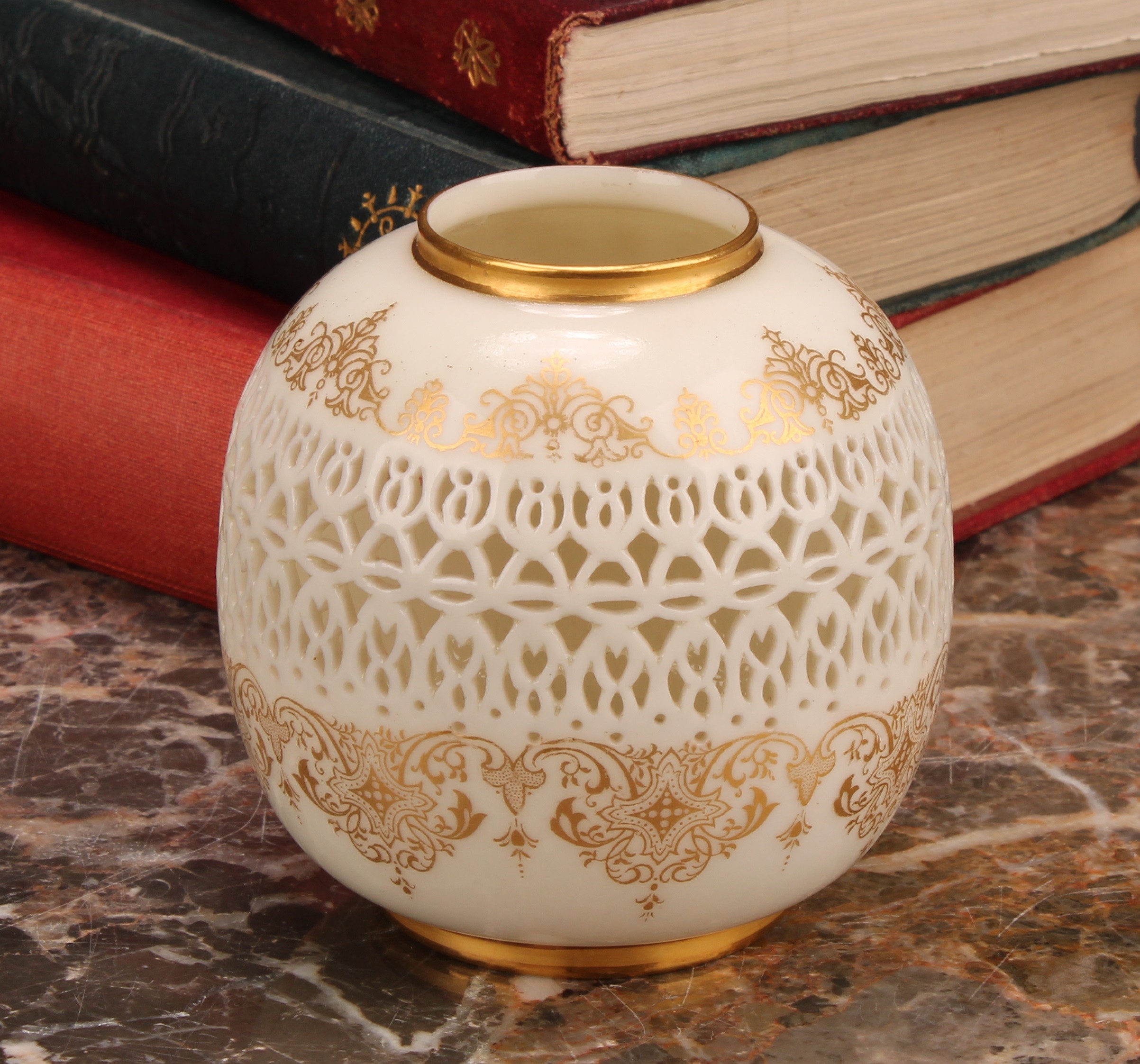 A Royal Worcester ovoid reticulated vase, by George Owen, outlined with gilt bands of scrolls and