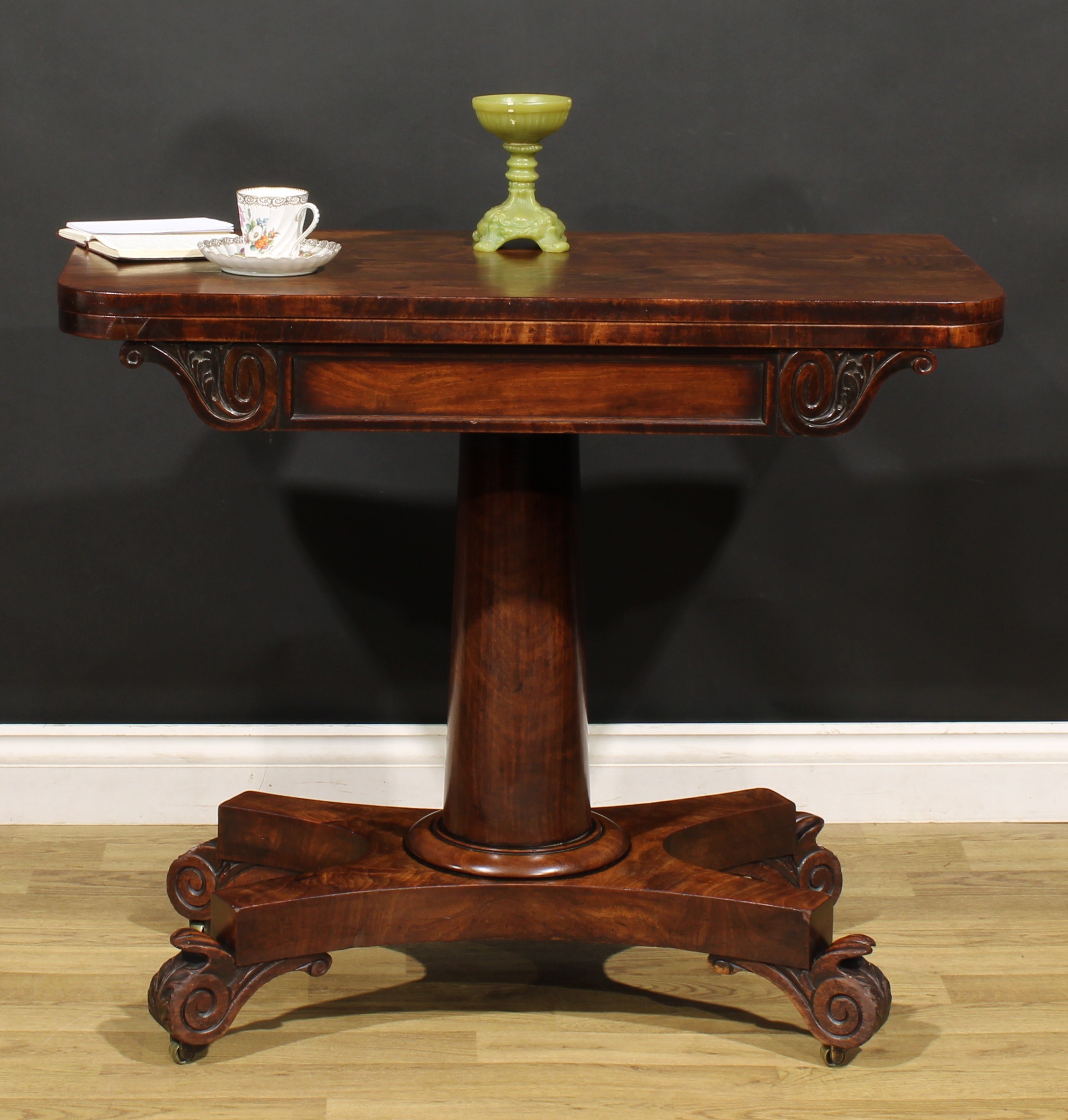 A George/William IV mahogany tea table, rounded rectangular folding top above a deep frieze carved