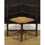An Arts & Crafts beech bobbin-turned corner chair, of small proportions, rush seat, 60.5cm high,