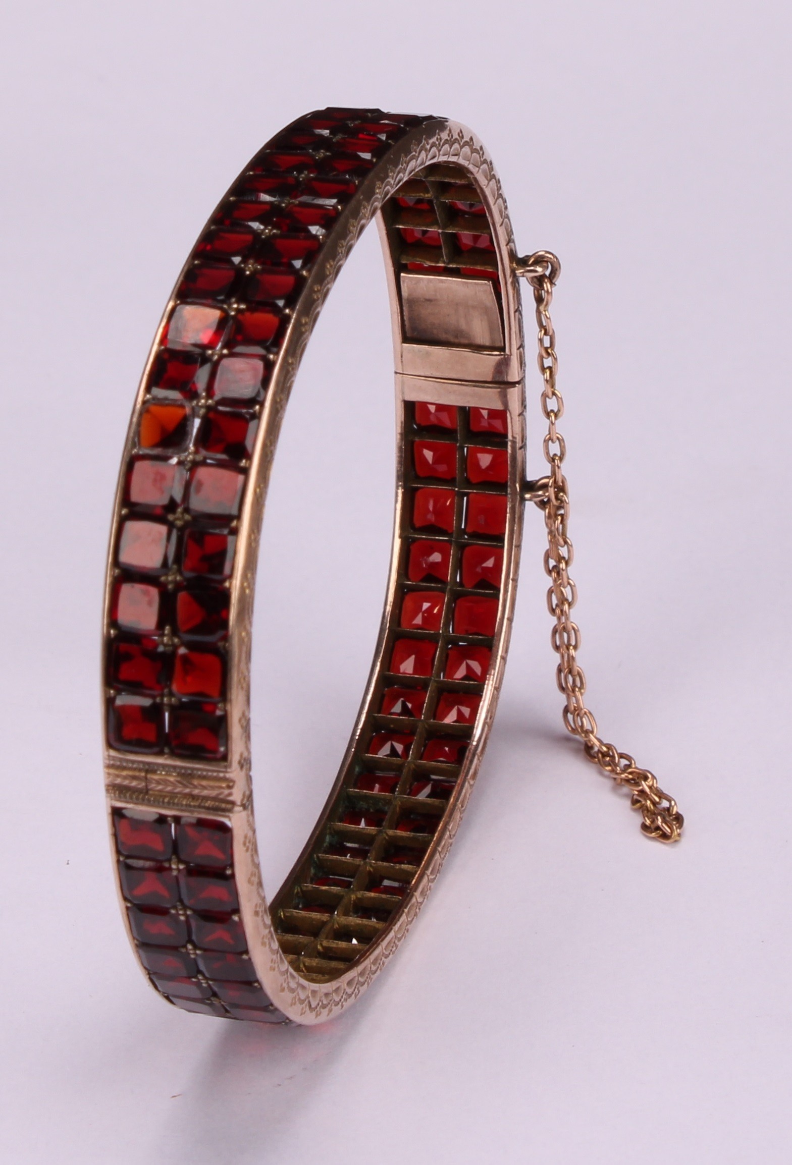 A continental gold bangle, applied with a double row of asscher cut channel set garnets, the - Image 4 of 5