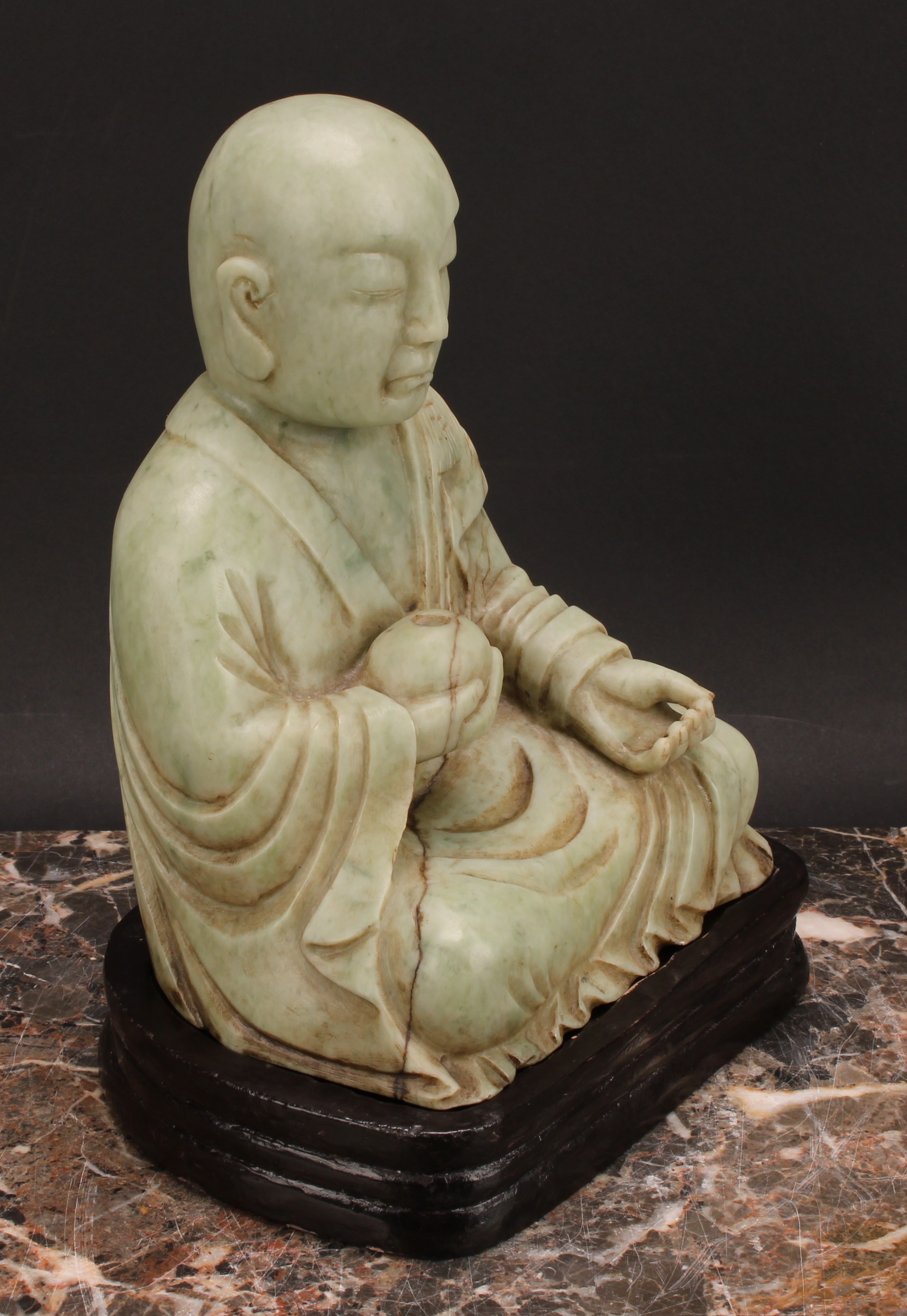 A Chinese soapstone figure, carved as a Buddhist disciple, or Luohan, holding a peach, 21cm high, - Image 3 of 4