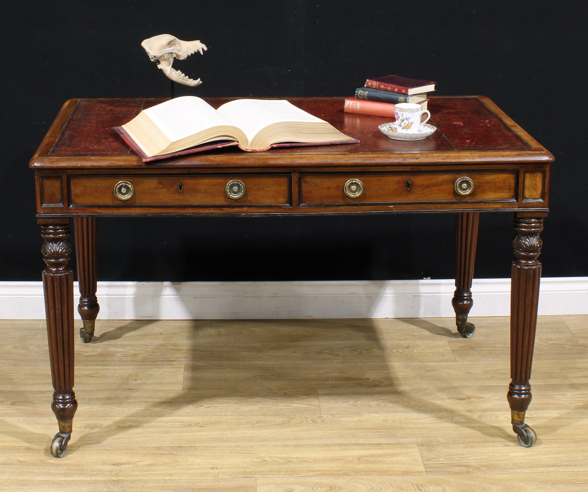 A George IV mahogany room centre library writing table, rounded rectangular top with inset tooled