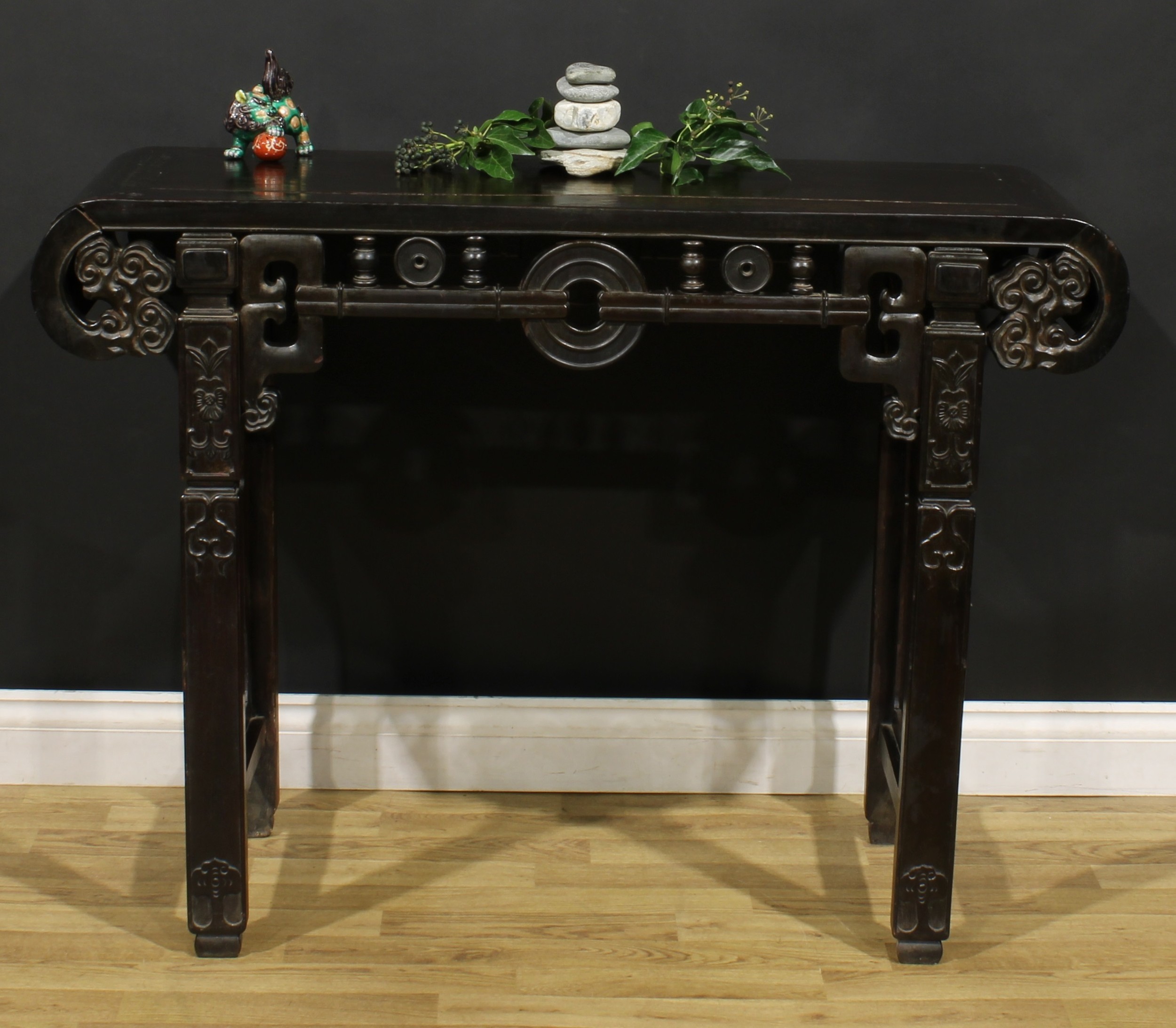 A Chinese hardwood altar table, rectangular top with scroll ends carved with ruyi heads, shaped