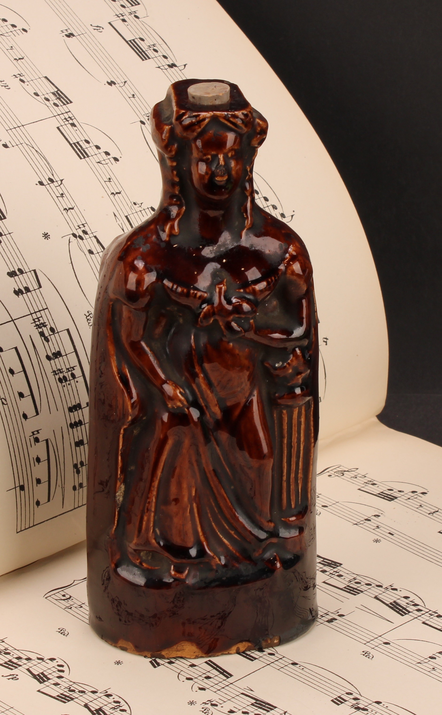 A 19th century treacle glazed reform flask, moulded on both sides as Queen Victoria, 18.5cm high