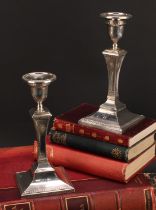 A pair of Edwardian silver square table candlesticks, in the Adam Revival taste, embossed with Neo-