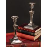 A pair of Edwardian silver square table candlesticks, in the Adam Revival taste, embossed with Neo-