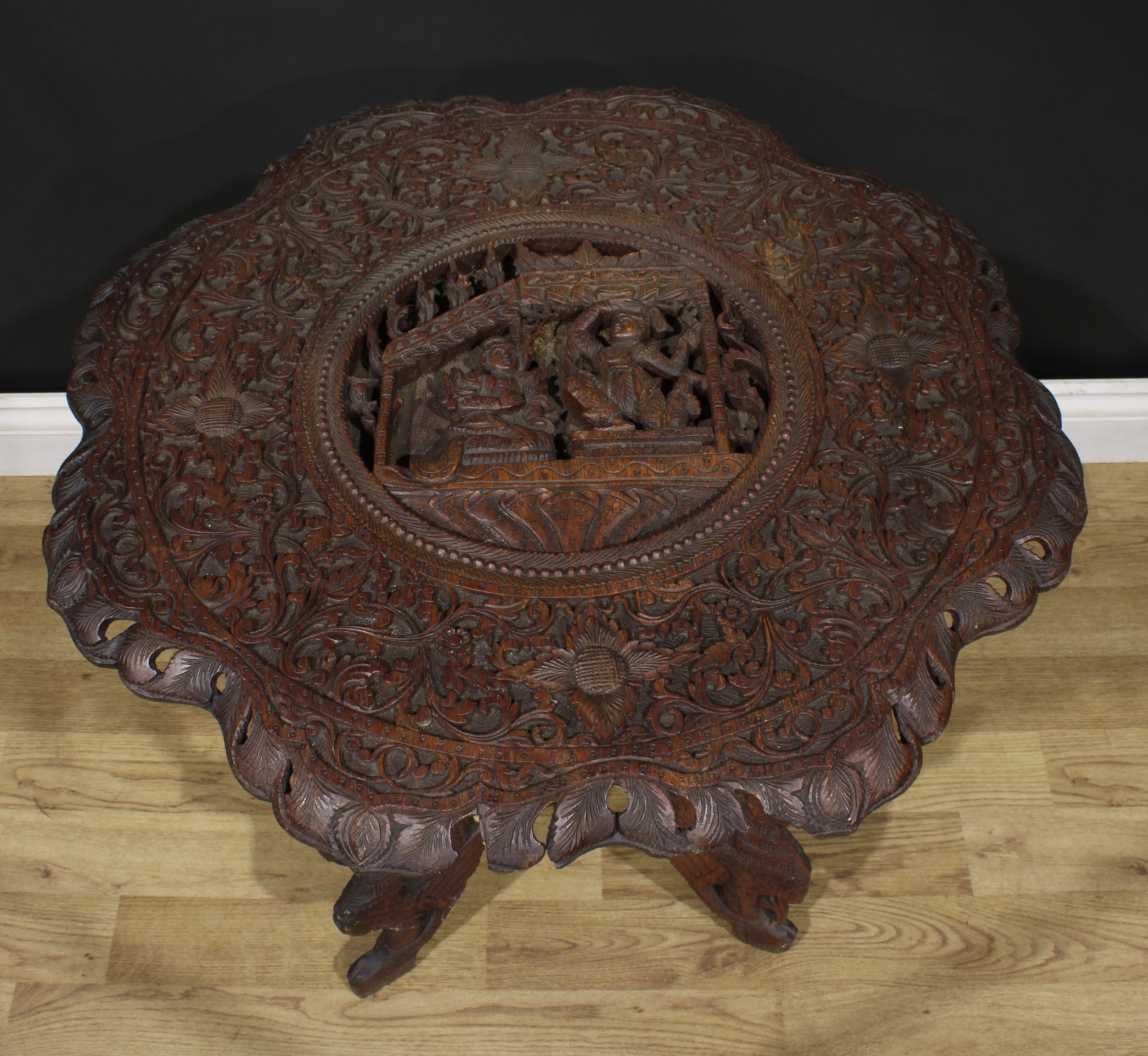 An Anglo-Indian hardwood occasional table, shaped circular top carved with deities within a band - Image 3 of 3
