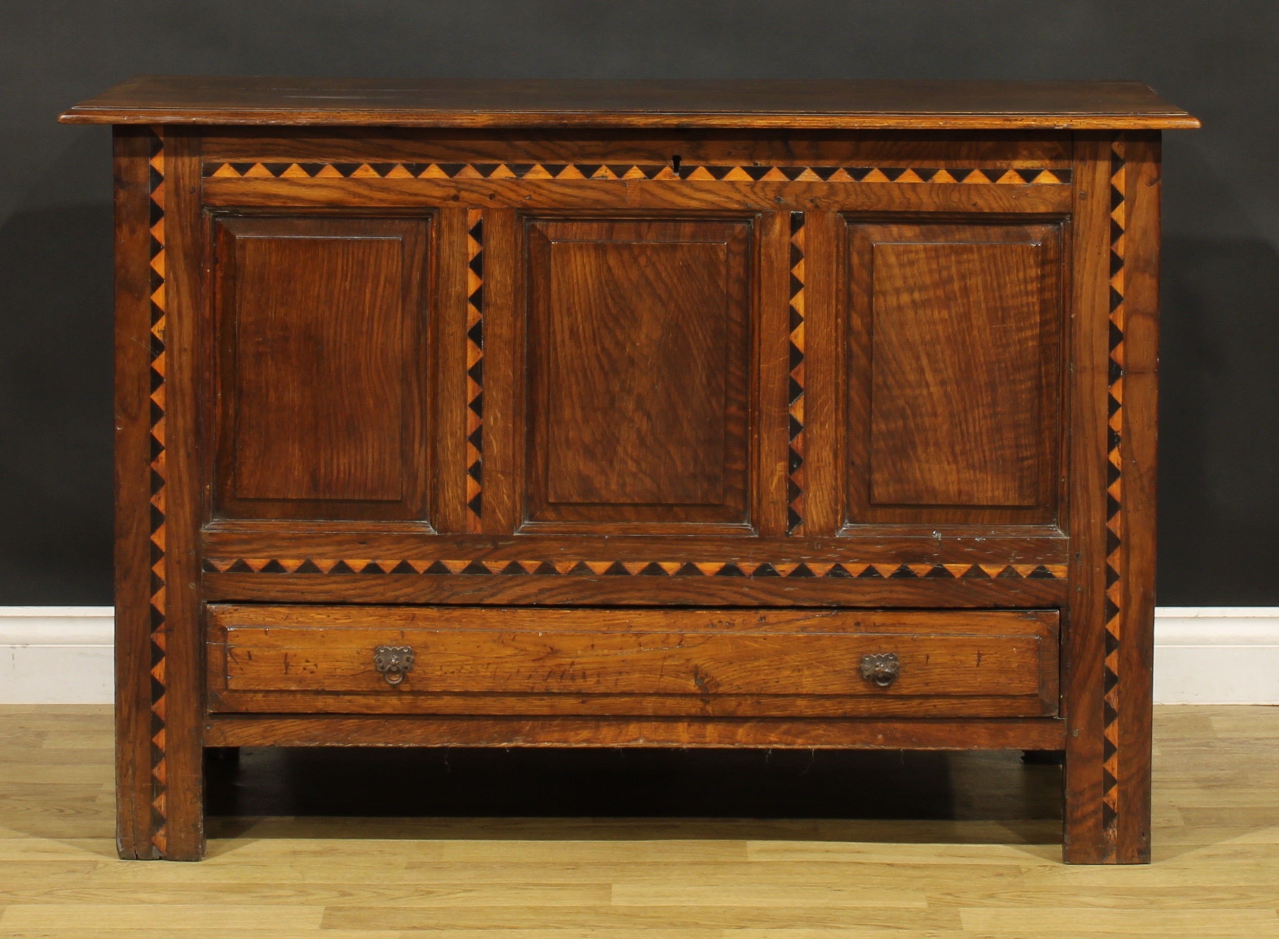 An 18th century design oak mule chest, hinged top above three raised and fielded panels outlined