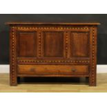 An 18th century design oak mule chest, hinged top above three raised and fielded panels outlined