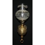 A 19th century brass wall mounted globular oil lamp, cast with foliate scrolls and Greek key border,