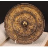 A Chinese gilt bronze mirror, cast in the Archaic taste, 21.5cm diam
