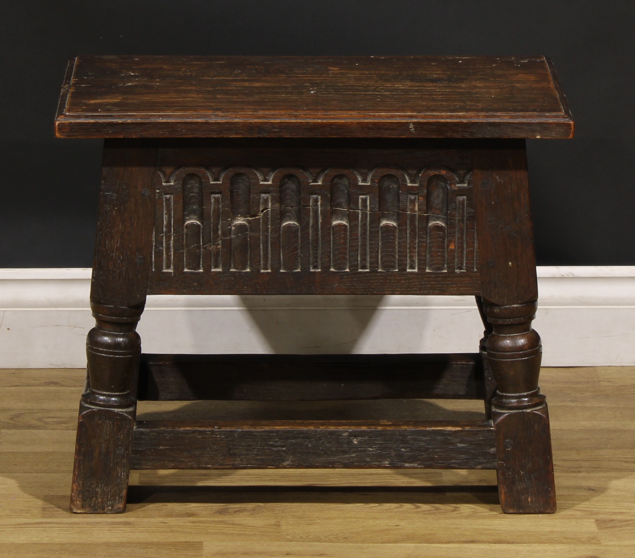 A Charles II style oak box stool, hinged top above a stop-nulled frieze, 43.5cm high, 54cm wide,