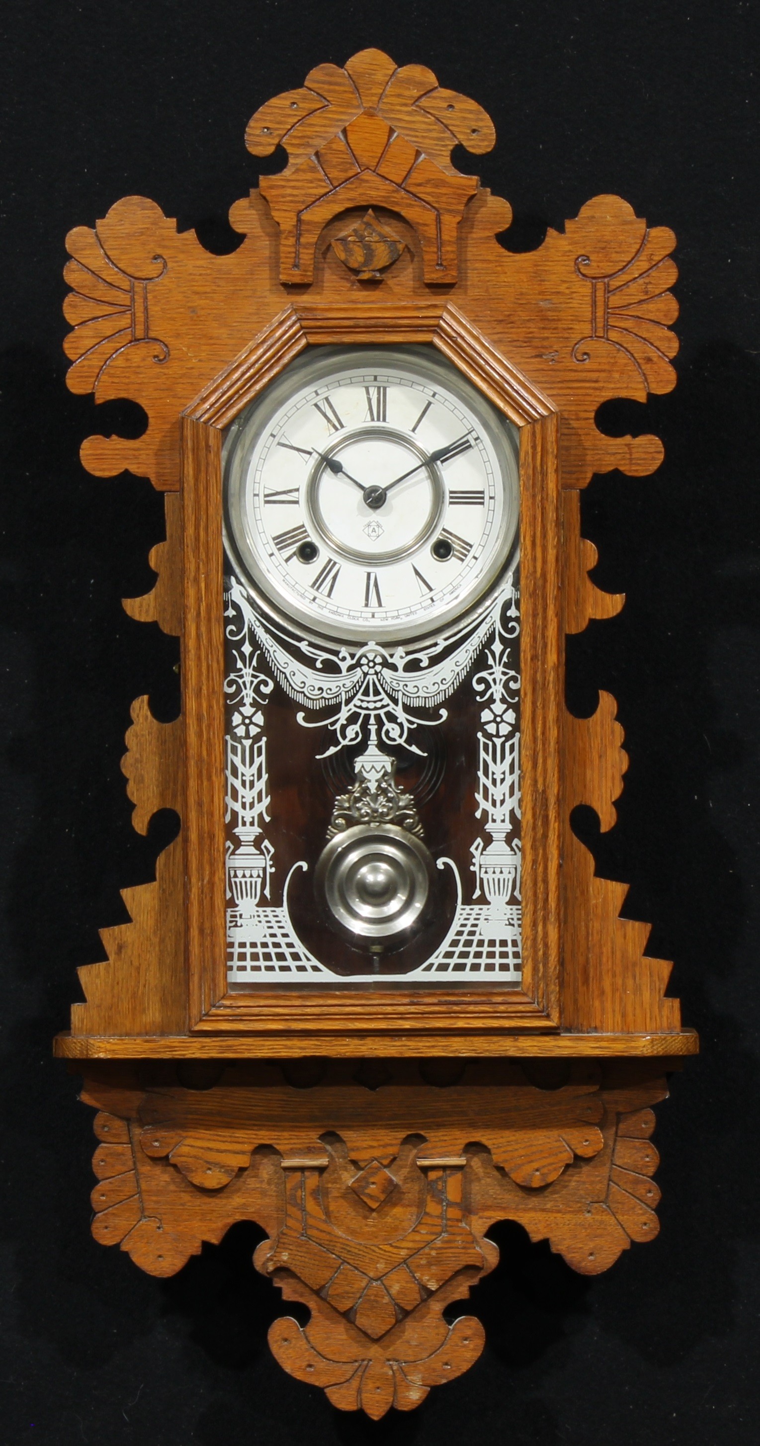 An early 20th century American oak gingerbread wall clock, by The Ansonia Clock Company, 13cm