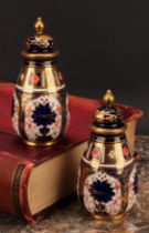 A pair of Royal Crown Derby 1128 Imari pattern ovoid vases, shaped domed covers moulded with sinuous