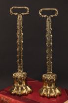 A pair of 19th century brass door stops, each cast as a lions paw, posted handles, lead-weighted