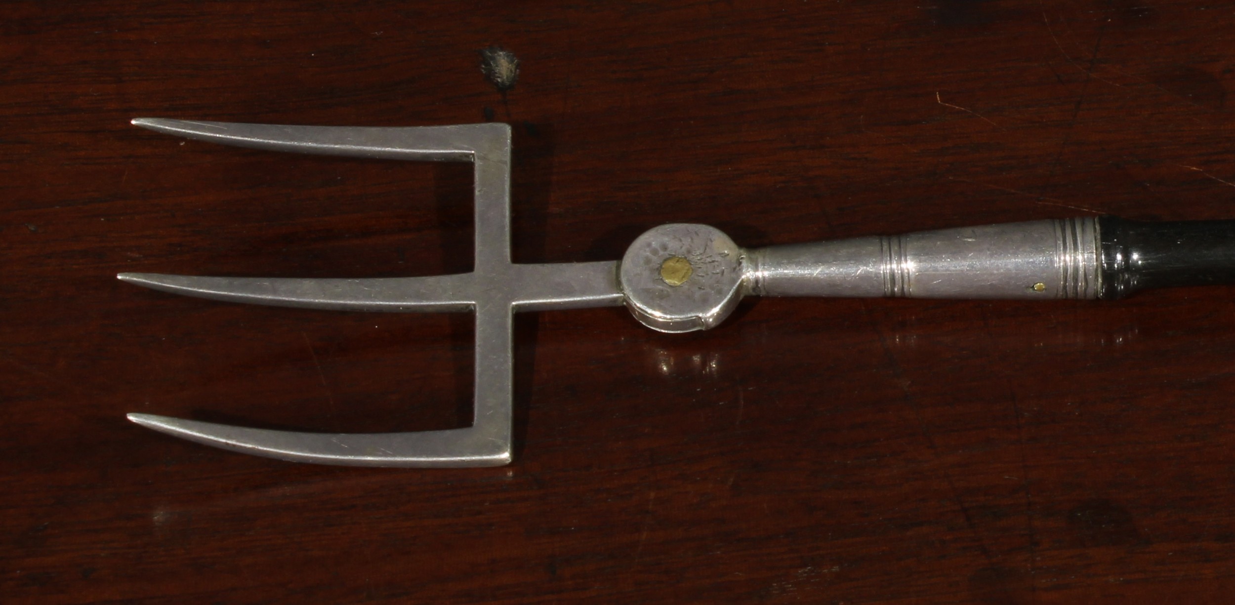A George III silver toasting fork, the three-prong terminal adjustable on a pivot, turned ebonised