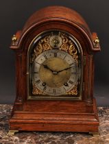An early 20th century oak bracket-form mantel clock, 14cm arched brass dial with silvered chapter