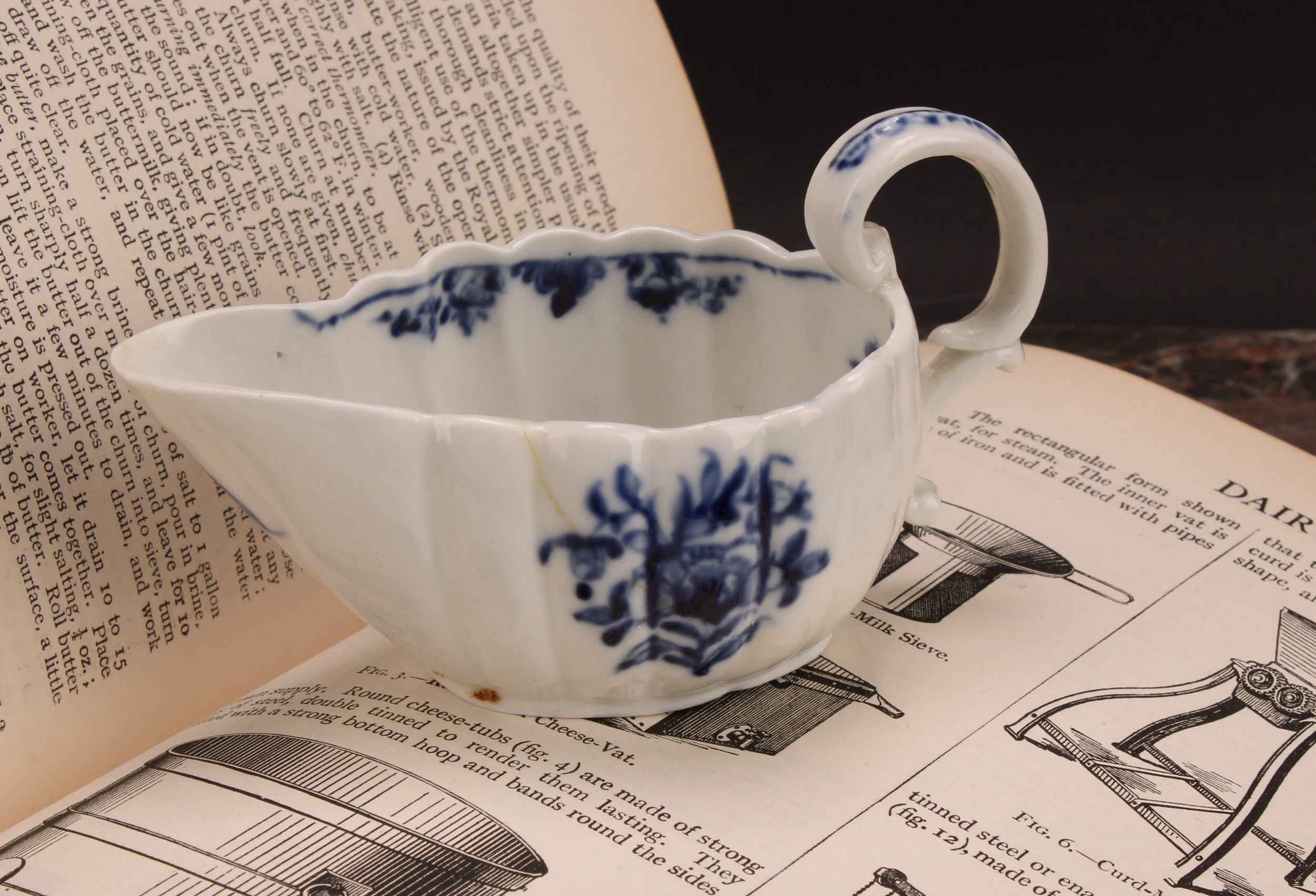 A Cookworthy Bristol butter boat, of fluted form, painted in underglaze blue with flowers, 11cm