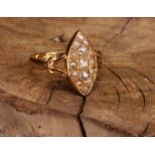 A diamond, seed pearl and 18ct gold navette shaped ring, set with three diamonds within 12 seed