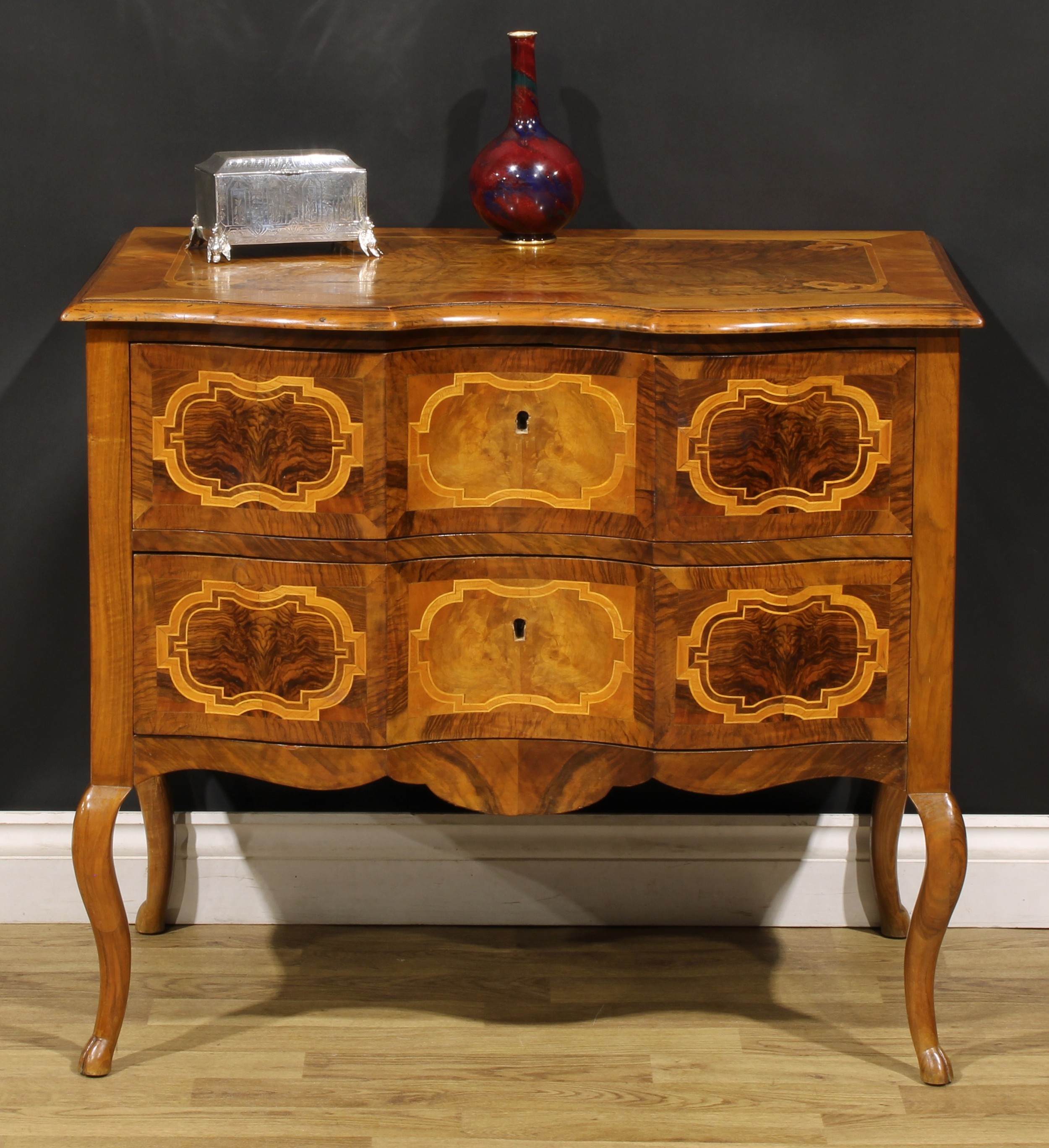 An 18th century style Italian walnut serpentine commode, oversailing top above a pair of long