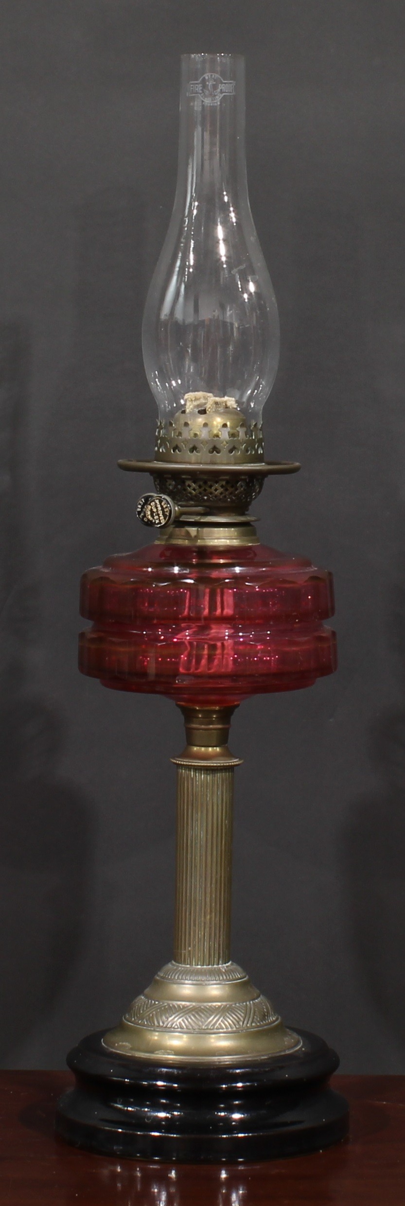 A late Victorian/Edwardian oil lamp, Duplex burner, facetted cranberry glass font, brass column - Image 3 of 3