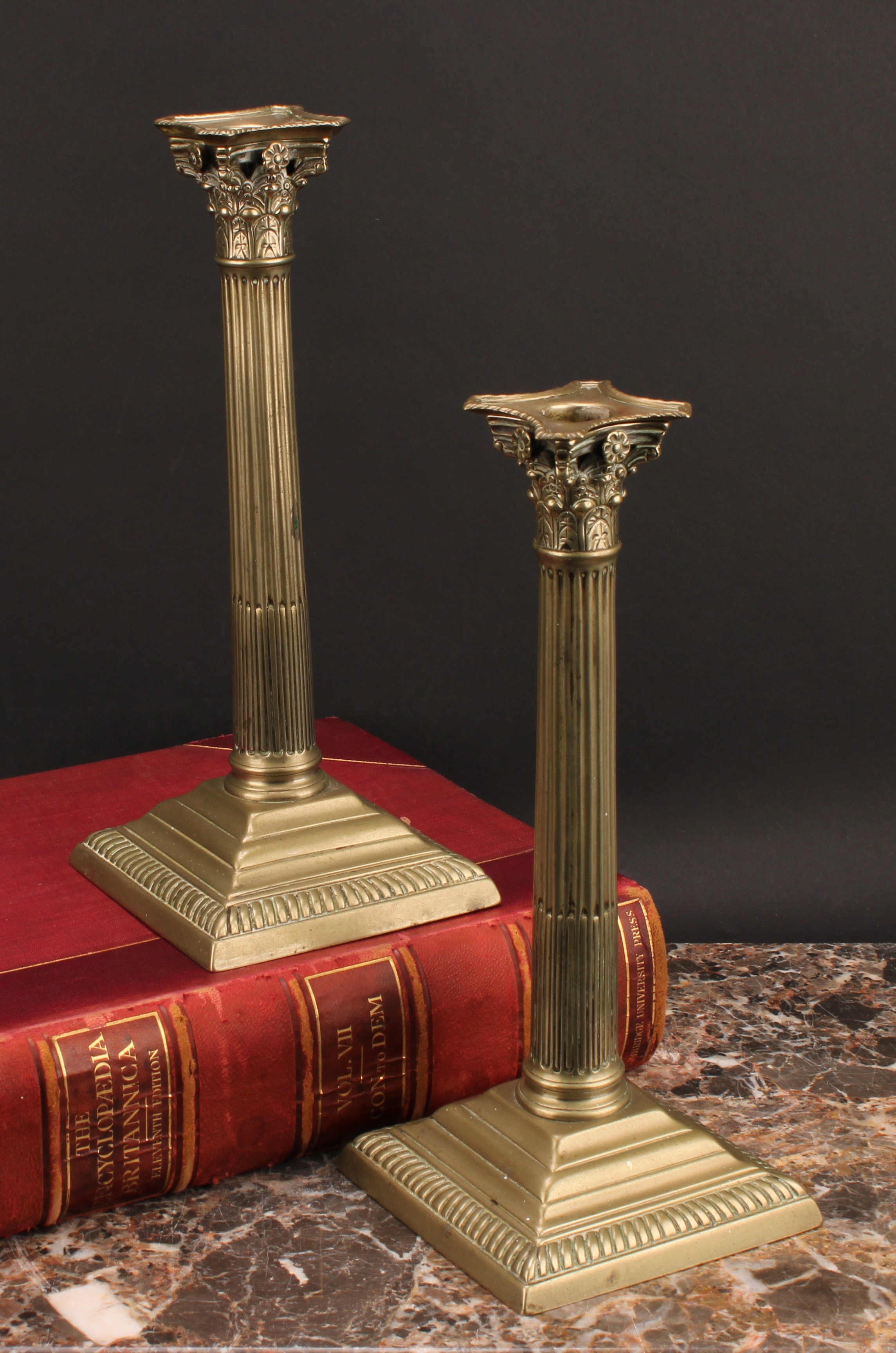 A pair of George III base metal stop-fluted Corinthian column candlesticks, stepped square bases,