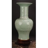 A large Chinese celadon baluster vase, moulded with lotus, 53cm high, seal mark, hardwood stand