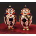 A pair of Royal Crown Derby 1128 Imari pattern ovoid pedestal vases and covers, circular bases, 13cm