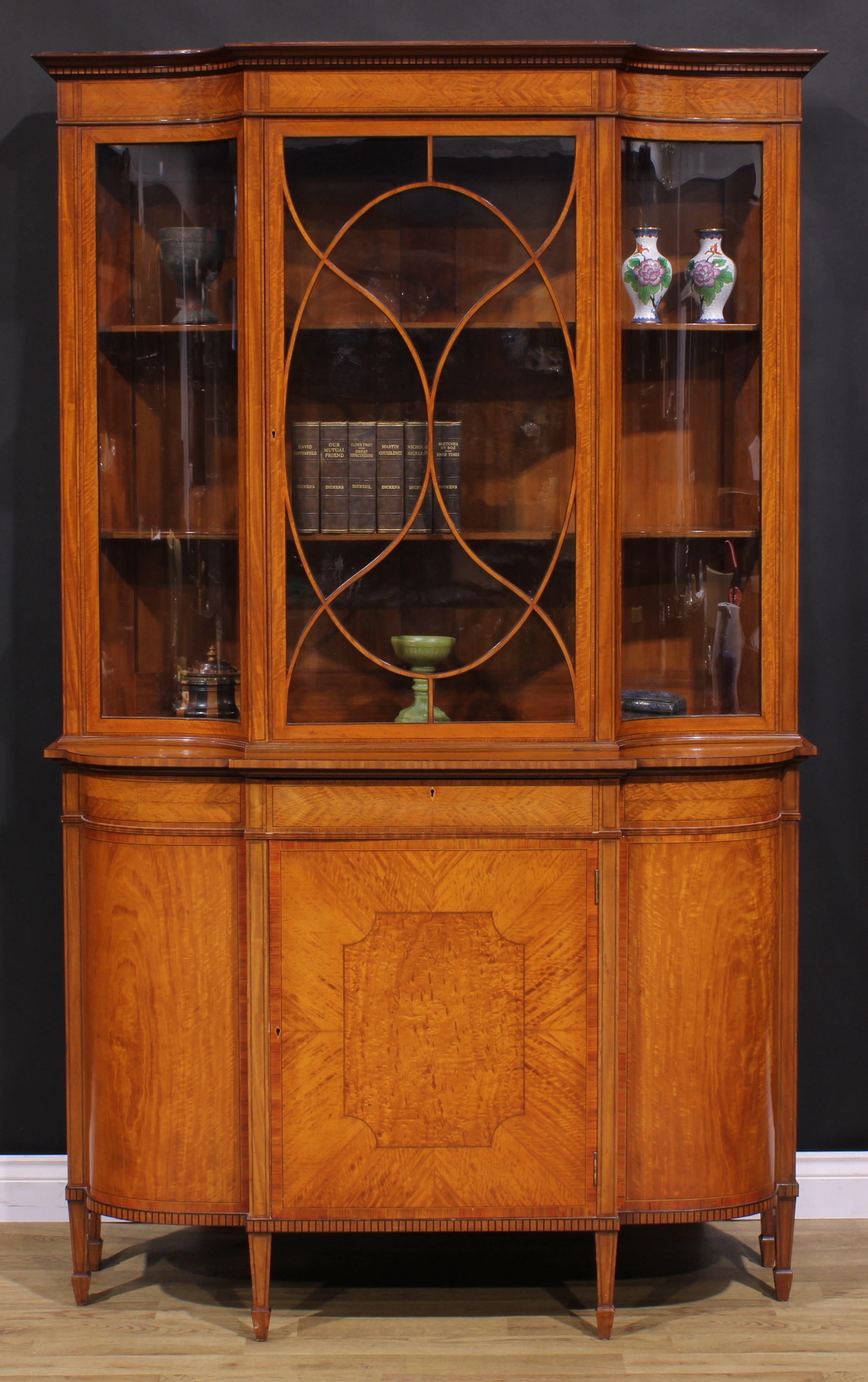 An Edwardian Sheraton Revival tulipwood and rosewood crossbanded satinwood break-centre display