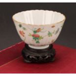 An 19th century Chinese fluted circular bowl, painted in the famille verte palette with flowers