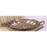 A German silver shaped oval fruit dish, chased in bold relief with leaves and ripe fruit, rustic