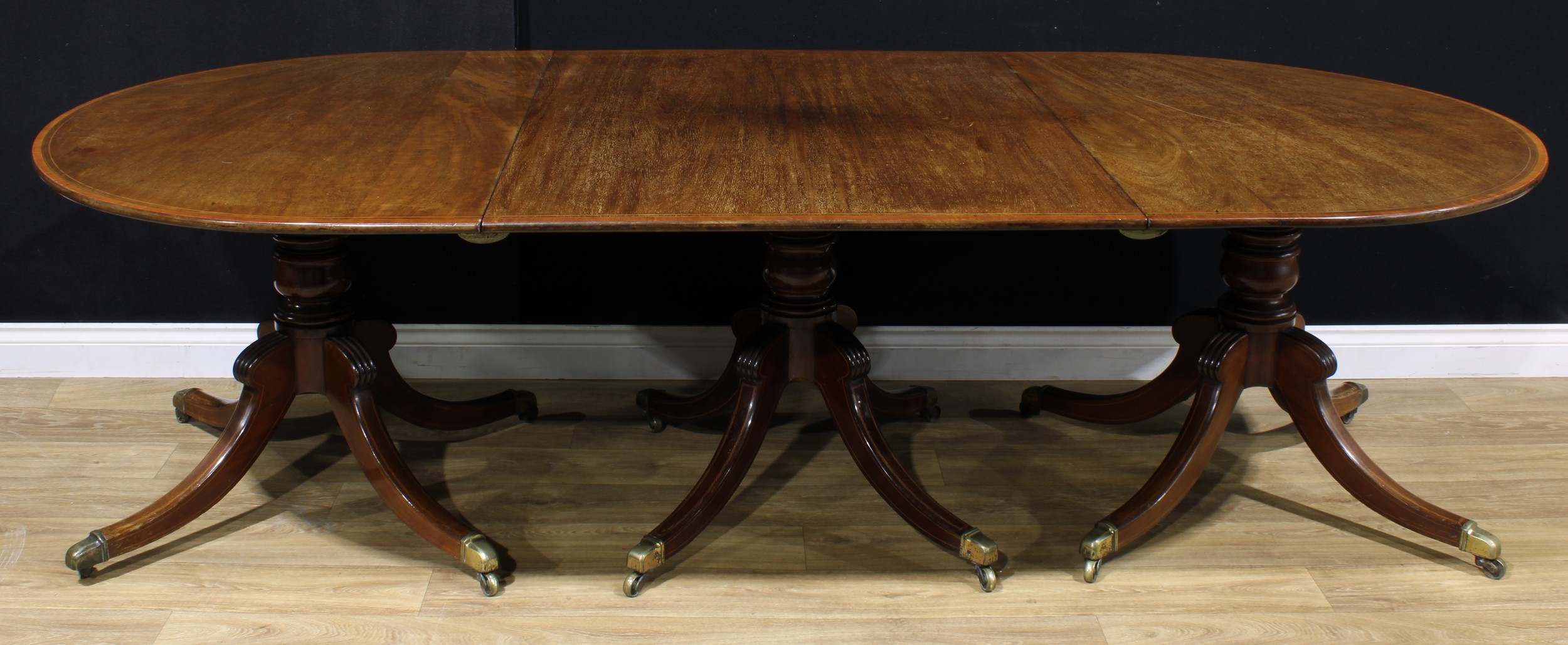 A Post-Regency mahogany triple-pillar dining table, each tilting top crossbanded with satinwood - Image 2 of 2