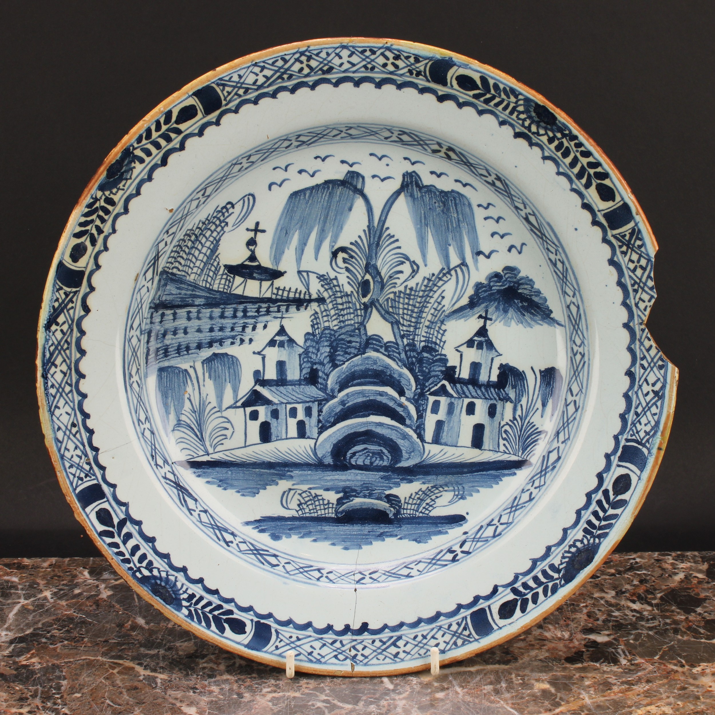 An 18th century English Delft charger, painted in underglaze blue with chinoiserie buildings, - Image 3 of 4