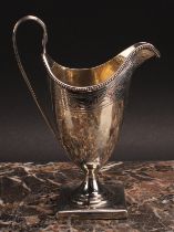 A George III silver helmet shaped cream jug, bright-cut engraved and outlined with wrigglework,