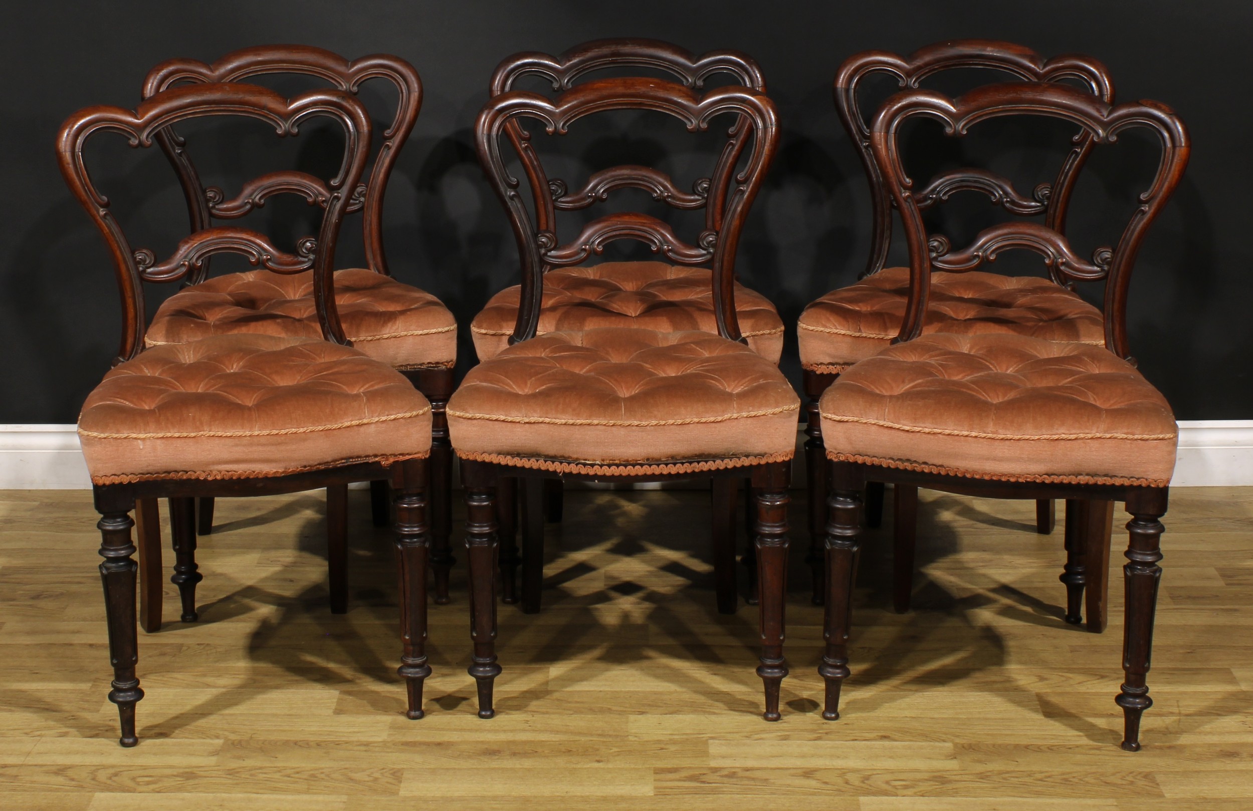 A set of six early Victorian solid rosewood dining chairs, cartouche shaped backs, stuffed-over