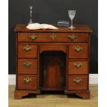 A George III mahogany kneehole desk, slightly oversailing top above an arrangement of eight drawers,