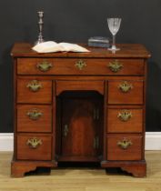 A George III mahogany kneehole desk, slightly oversailing top above an arrangement of eight drawers,