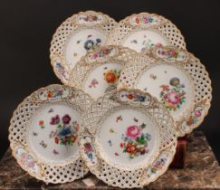 A set of six German porcelain shaped circular plates, decorated with flowers, pierced borders picked