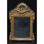 A Baroque parcel gilt and painted looking glass, rectangular plate, the shaped cresting centred by a
