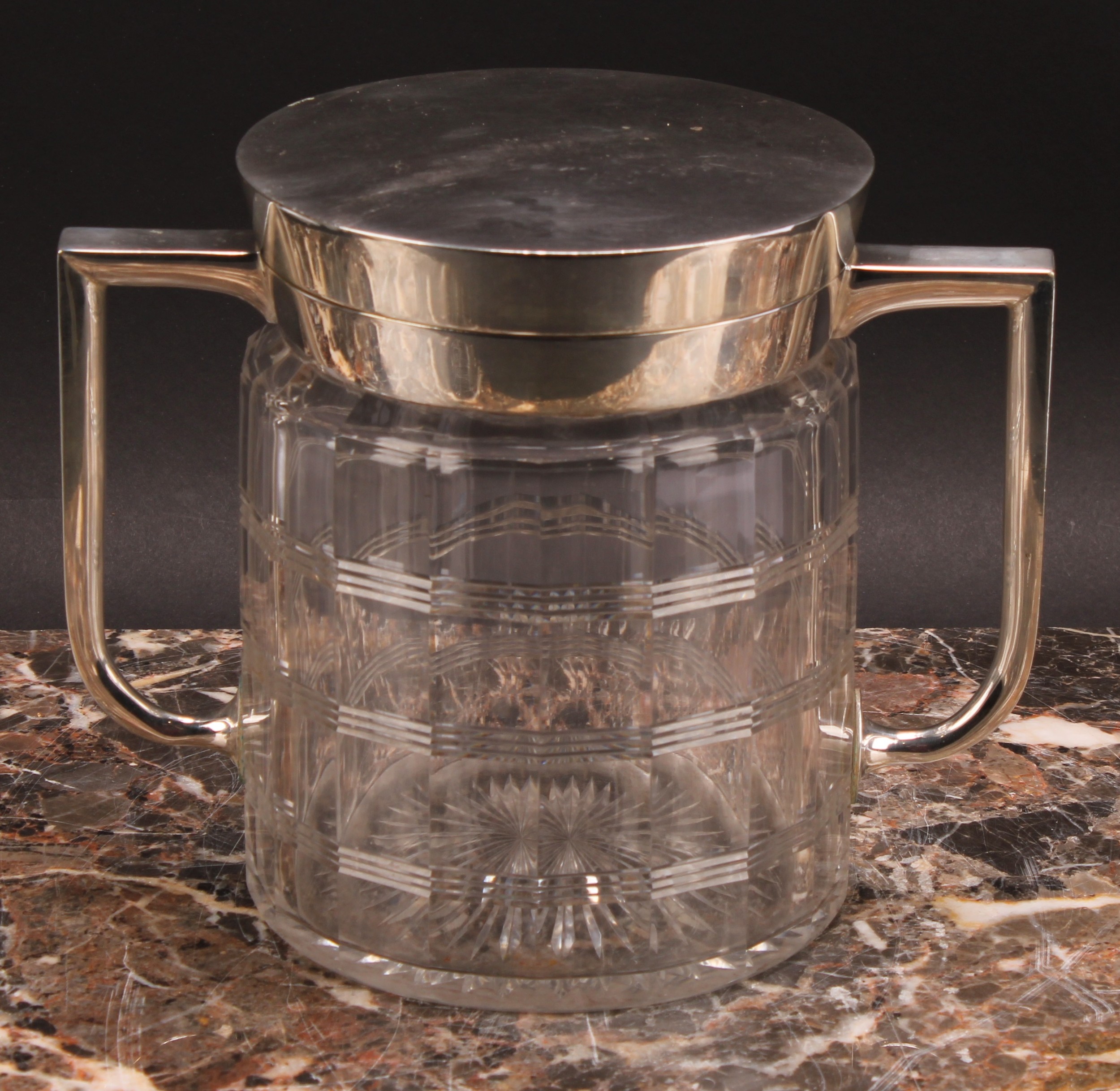 An Arts and Crafts E.P.N.S mounted clear glass biscuit box, of Christopher Dresser influence, hinged