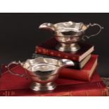 A pair of early George II silver sauce boats, wavy borders, scroll handles, cast bases, 19.5cm long,