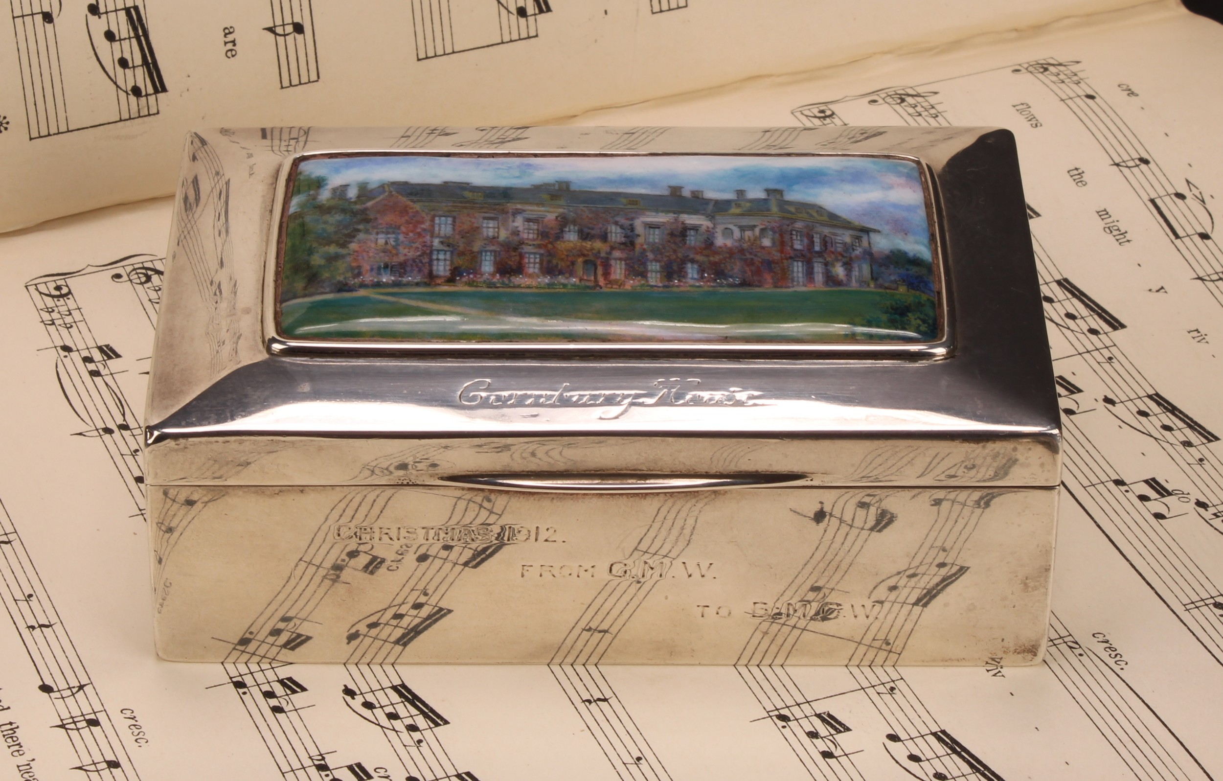 An Arts and Crafts silver and enamel rectangular box, hinged cover decorated with a named view of